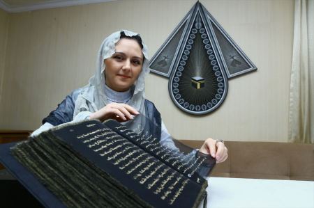 صور ... أذرية تكتب المصحف الشريف على الحرير 